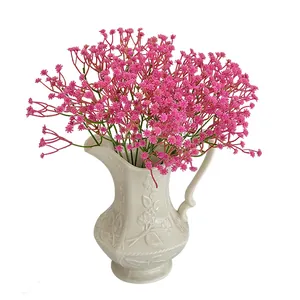 Pink artificial babys breath flowers in white vintage ceramic vase for home decoration
