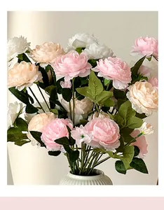 Pale pink and cream artificial ranunculus in a white textured ceramic vase for decor