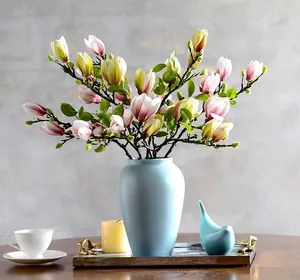Détail de fleurs de magnolia en soie rose dans un vase en céramique bleue pour la maison