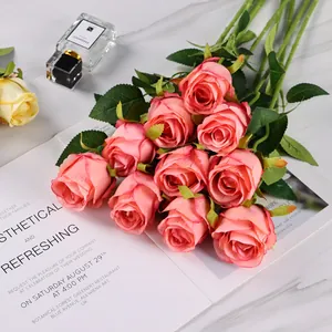Close-up of pink artificial roses with gradient petals on a marble surface background