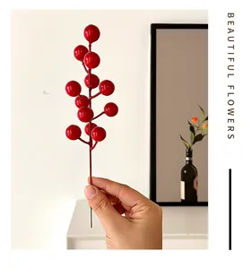 Detailed view of vibrant artificial red berries branch in a minimalist home decor setting