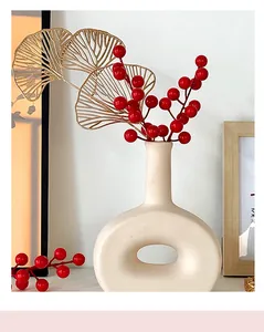 Modern cream ceramic vase with hollow base, gold ginkgo leaves and red berries