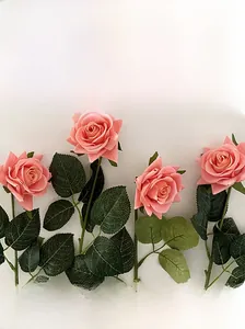 Close-up of pink artificial roses featuring realistic petal texture and green leaves