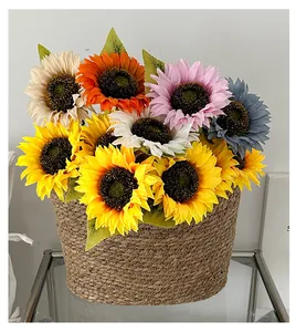 Detalle de girasoles artificiales de colores en una cesta tejida para decoración de hogar