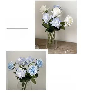 Detailed view of realistic light blue and white roses in transparent glass vases
