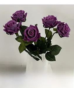 Detailed view of realistic purple artificial roses in a minimalist white vase for home decor