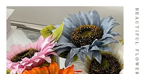 Detalle de girasoles artificiales con pétalos realistas y follaje sobre una base reflectante