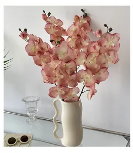 Bouquet di orchidee rosa in un vaso di ceramica bianco con manico a onda decor