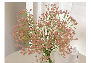 Close-up of realistic pink gypsophila faux flowers in a clear glass vase for decor
