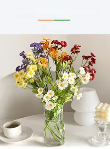 Colorful artificial daisy bouquet in glass vase for modern home table decoration