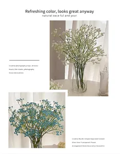 Detalle de flores de paniculata artificiales azules y blancas en jarrón de vidrio