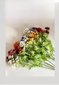 Close-up of vibrant artificial chamomile flowers with realistic petals and green leaves