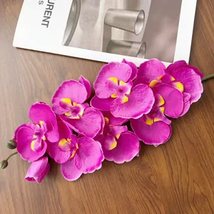 Dettaglio di ramo di orchidea finta fucsia a 8 teste su sfondo in legno scuro