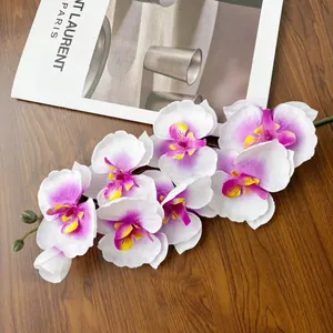 Dettaglio di orchidea artificiale bianca con bordi viola su legno scuro