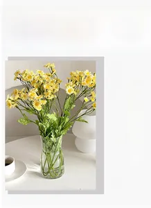 Artificial chamomile daisies in a glass vase on a desk for home and office decoration