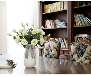 White artificial Lisianthus bouquet in vase with bow for home interior decoration