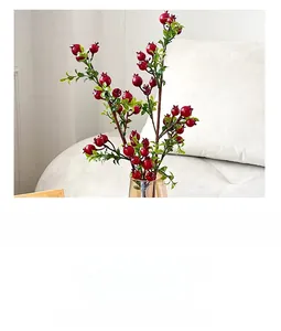 Detail showing artificial red pomegranate branches with green leaves for home decor