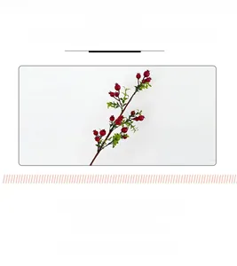 Close-up of lifelike artificial red pomegranate berries and green leaves for home decor