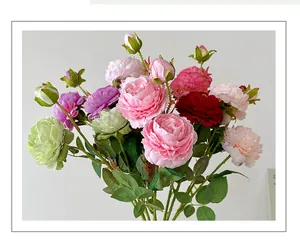 Close-up of realistic faux peonies and roses with delicate pink petals and green leaves