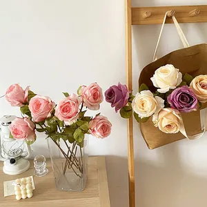 Ramo de rosas artificiales vintage con bordes quemados en jarrón de vidrio de boda