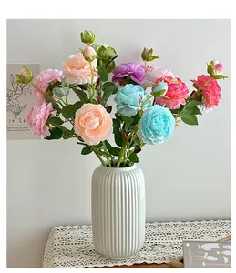 Close-up of colorful silk peonies and roses in a white ceramic vase for home decor