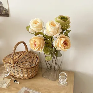 Rosas artificiales vintage con bordes quemados en champán y amarillo con jarrón de vidrio