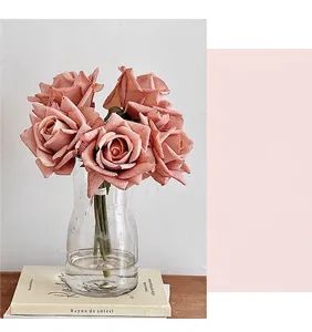 Detailed view of artificial vintage pink roses in a clear glass vase for home decor