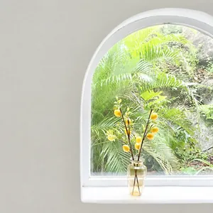 Artificial lemon branch with yellow fruit in amber glass vase for home decor