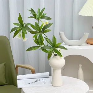 White ceramic vase with spiral texture and artificial green plant for home decor
