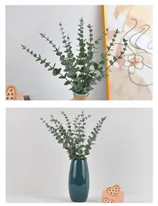 Détail de feuilles d'eucalyptus artificielles givrées dans un vase en céramique