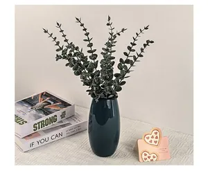 Vase en céramique bleu brillant avec feuilles d'eucalyptus pour décoration d'intérieur