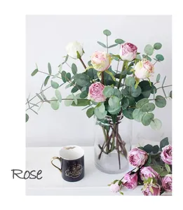 Nahaufnahme künstlicher Rosenstrauß mit Eukalyptusblättern in einer Glasvase