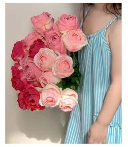 Child holding a bouquet of realistic artificial burnt roses in red and cream hues