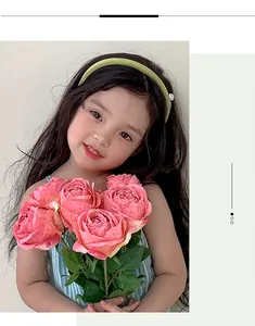 Close-up of a young girl holding a large bouquet of pink artificial burnt roses