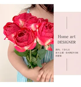 Detailed close-up of realistic dark pink burnt-edge silk roses held in hand for home decor