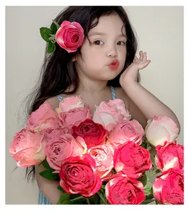 Detail of a young girl holding a realistic pink burnt edge artificial rose bouquet