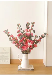 Primer plano de rosas artificiales rosas en un jarrón cerámico vintage sobre una mesa