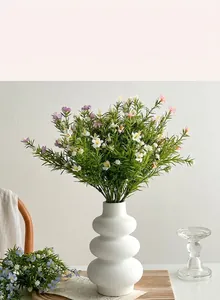 Artificial babys breath in a wavy white vase for modern minimalist home decor