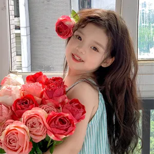 Realistic pink and red curled rose bouquet held by a girl in soft natural light