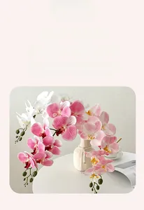 Close-up of artificial phalaenopsis orchids with realistic texture in a white vase