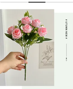 Close-up of realistic pink silk roses with green leaves for wedding decor and photography