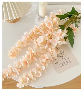 Detail of peach wisteria hanging flowers with green leaves for wedding ceiling decor
