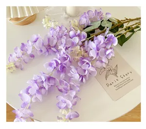 Detail of lifelike wisteria flower strings with purple gradient petals for wedding decor