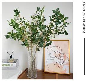 Gros plan du vase en verre martelé avec des plantes vertes artificielles dans un décor douillet