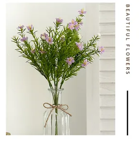 Close-up of purple and white artificial flowers in a glass vase with a burlap bow