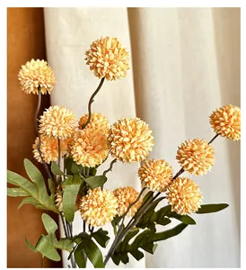 Vista macro de crisantemos pompones artificiales amarillos con pétalos y hojas realistas