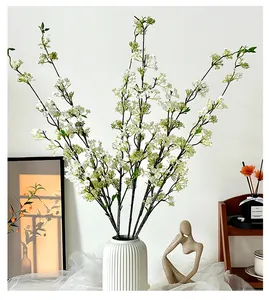 Close-up of artificial white snow willow branches in a white ceramic vase for home decor