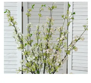 Close-up of artificial snow willow branches with delicate white and pink gradient flowers