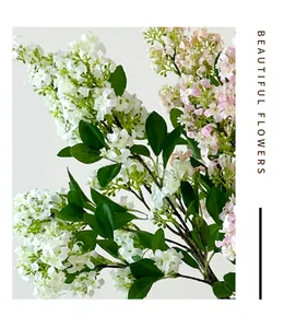 Close-up of artificial lilac flowers with realistic white petals and green leaves