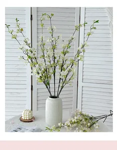 Detail of faux white floral branches in a ceramic vase for elegant home interior decor